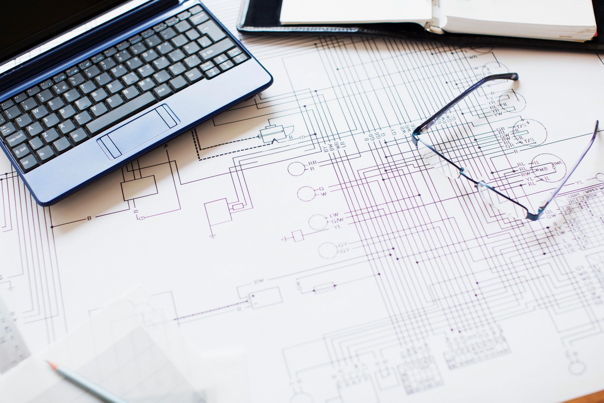 Systems engineering blueprint and laptop on a desk